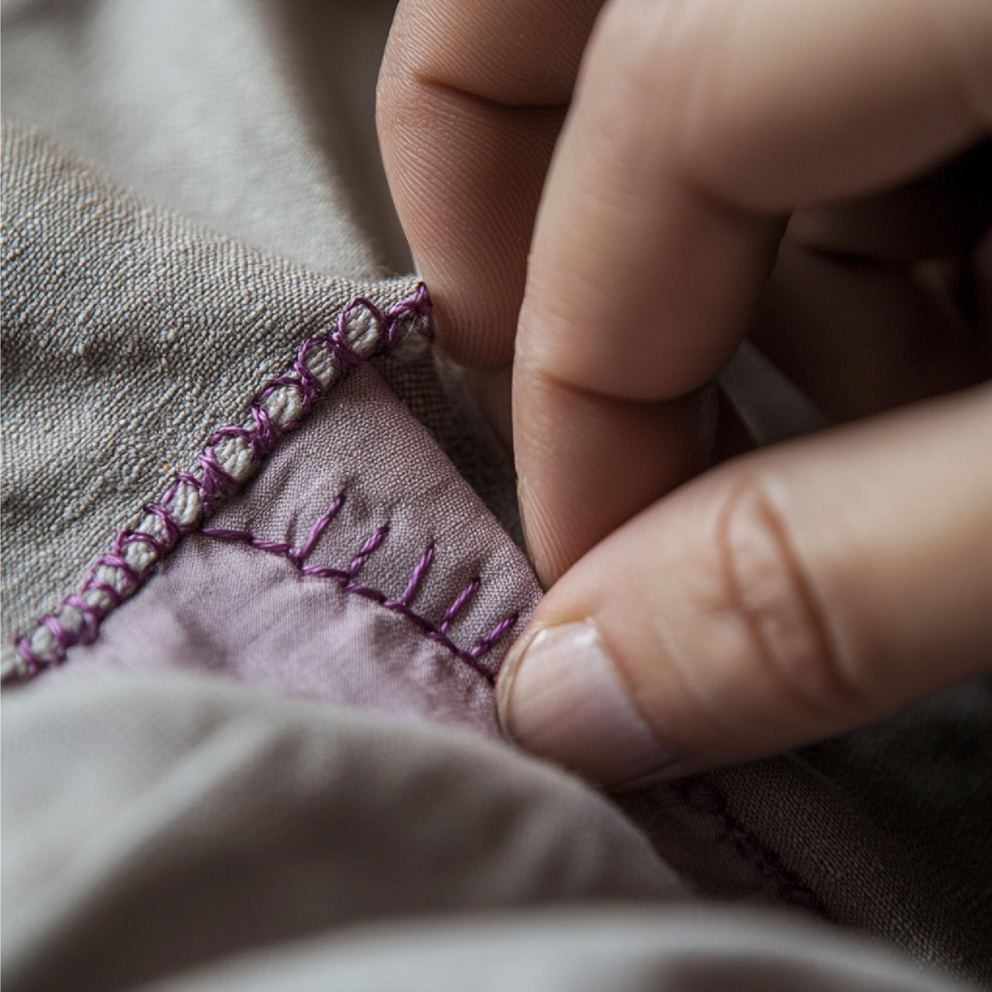 Näheaufnahme handgestickter Details auf Leinen